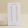 The JaxKelly Gemstone Chain Drop - White Opal earrings feature white opal beads and 18k gold plating, displayed on a branded OPAL joy card against a neutral background.