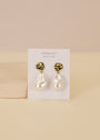 Abstract Pearl and Gold Drop Earrings feature oversized, baroque-style white pearls on irregular gold-plated studs with sterling silver posts, displayed on a JaxKelly card against a neutral background.