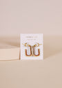 Brown Enamel Large Rectangle Gold Hoop Earrings displayed on a JaxKelly-branded white card against a beige background. These 18k gold-plated hoops feature brown enamel for a modern, stylish touch to any outfit.
