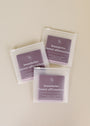 Three Boundaries Shower Affirmations™ square pouches with white text on a purple background are arranged on a beige surface. Each includes 25 reusable, waterproof affirmation cards—ideal for daily self-care.