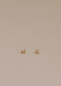 Teardrop Stud - Champagne CZ: Mini teardrop earrings with 18k gold plating and sterling silver posts, minimalist design, displayed on a plain light beige surface.