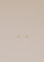 The Teardrop Stud - Clear CZ features small, gold-plated stud earrings with clear cubic zirconia and sterling silver posts, shown on a light beige background.