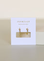 The Open Mini Hoop Earring - Champagne features 18K gold plating and sparkling champagne CZ stones, displayed on a white JaxKelly card with "Wear Good Vibes" against a neutral, minimalist background.