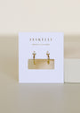 The Open Mini Hoop Earring - White features small gold hoops with sterling silver posts and a single clear gemstone, displayed on a white JaxKelly "Wear Good Vibes" card against a neutral background.