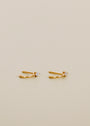The Open Mini Hoop Earring - White features 18K gold plating, sterling silver posts, and a single clear gemstone on each hoop, shown against a plain light beige background.