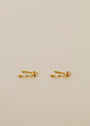 The Open Mini Hoop Earring - Champagne features delicate 18K gold plating and a round champagne CZ stone, styled as small hoops and showcased on a plain beige background.