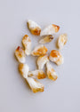 The Raw Citrine Crystal Set features several small, rough stones in white and golden-yellow hues, arranged in a scattered pattern on a light gray background.