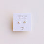 The Simple Stud - White Opal features small, round lab-grown white opal earrings with 18k gold-plated trim, displayed on a white JaxKelly card labeled "Opal joy" against a light background.