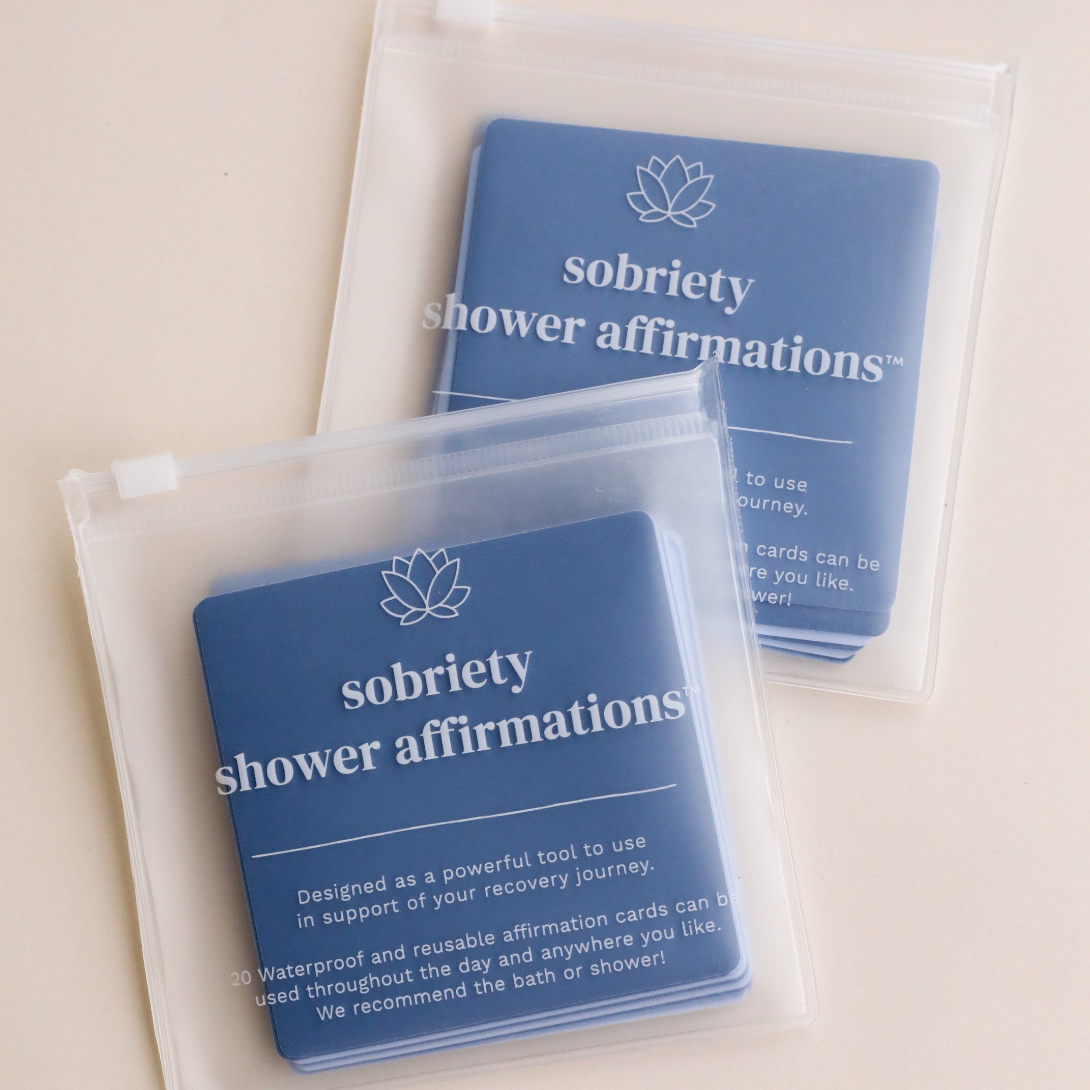 Sobriety Shower Affirmations™ includes two zippered pouches of waterproof cards with a lotus icon, offering supportive sobriety messages for your recovery—perfect for uplifting moments in the bath or shower.