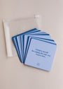 Sobriety Shower Affirmations™—a set of blue waterproof affirmation cards fanned out next to a transparent case. The top card reads, "I forgive myself for coping the only way I knew how"—perfect for your recovery journey.