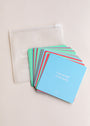 A stack of Teens Shower Affirmations™ waterproof cards for teens—top card reads "I am proud of my body"—is spread next to a clear zippered pouch on a light surface, perfect for daily positive mindset quotes.