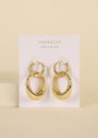 The Coupled Hoop - Earring features a shiny double oval hoop design with 18k gold plating, displayed on a white JaxKelly Wear Good Vibes card against a beige background.