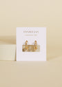 A pair of Double Hoop - Earring gold-plated with small crystal accents is displayed on a white JaxKelly Wear Good Vibes card, set against a beige background.