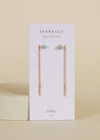 The JaxKelly Studded Threader - Fire Opal earrings, featuring 18K gold plating and lab-grown fire opal studs, are shown on a white card labeled JaxKelly and Opal Joy against a neutral background.