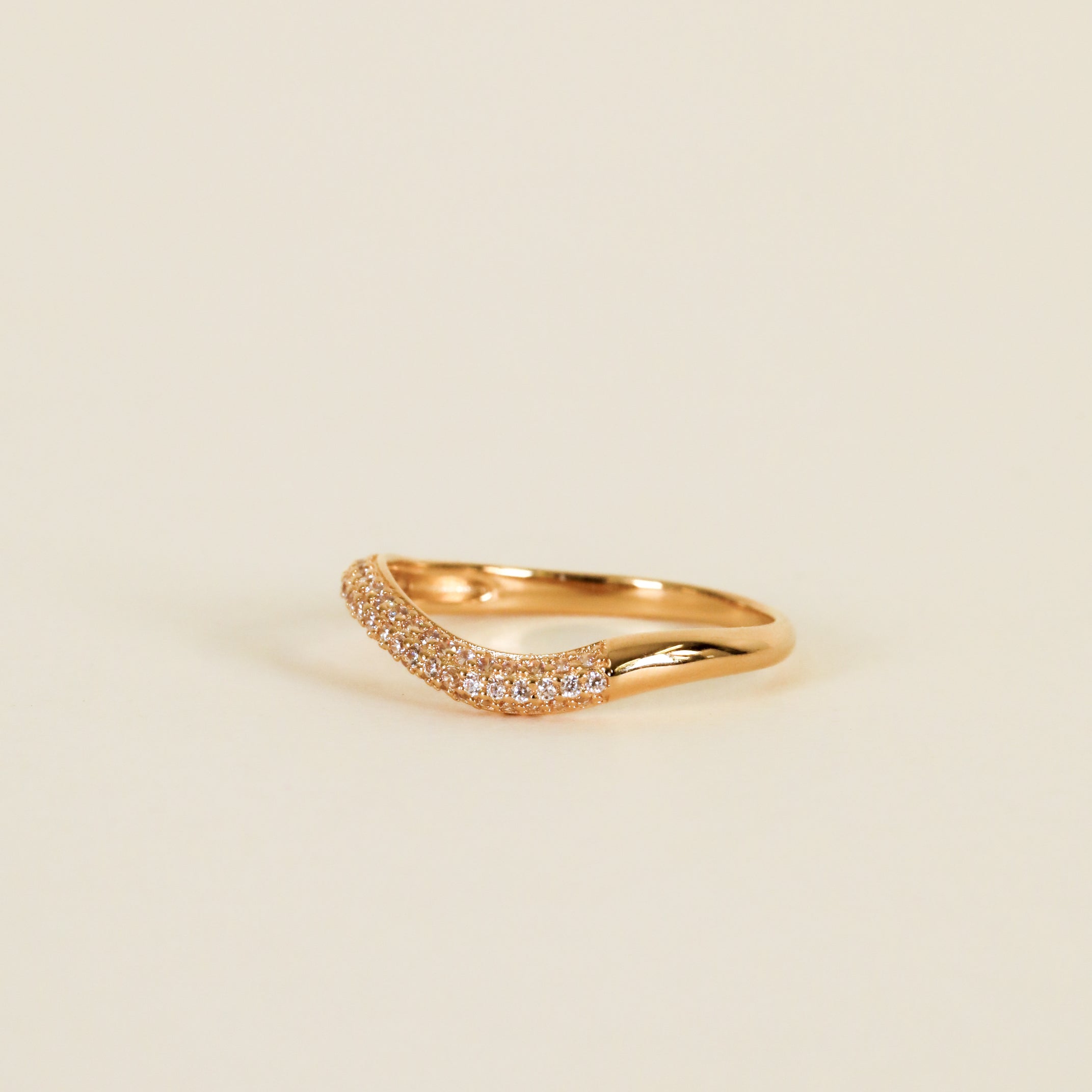 The Ring - Pave Wave - Champagne CZ features 18k gold plating and a curved band set with sparkling champagne cubic zirconia, shown against a plain, light background.