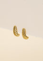 The Bold Swirl - Earring is a pair of small, gold-plated, ribbed hoops shown on a beige textured background—perfect as subtle statement jewelry.