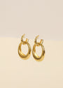 The Coupled Hoop - Earring features a pair of small, chunky double hoops with 18k gold plating, displayed on a neutral beige background.