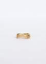 The Wave Ring, crafted in 18k gold with a wavy design, features two overlapping bands—one plain and one adorned with clear gemstones. Shown on a plain white background, this elegant piece offers lasting beauty.