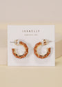 A pair of geometric, brown enamel Vintage Hoop Earrings with 18k gold plating displayed on a white JaxKelly card that says “Wear Good Vibes.”.