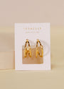 The Illusion Double Hoop - Gold Earrings are crafted from surgical-grade stainless steel with 18k gold plating, displayed on a white card featuring “JAX KELLY WEAR GOOD VIBES” in gold lettering against a neutral background.