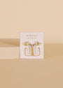 The White Color Dipped Large Rectangle Hoop Earrings are shown on a white JaxKelly card, standing upright against a beige background with a light rectangular block beside them.