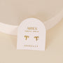 Zodiac Earrings - Aries: Gold plated studs with a small gem and sterling silver posts, shown on a white card labeled “Aries March 21 - April 19” and “JaxKelly,” set against a light neutral background.