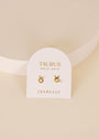 A pair of Zodiac Earrings - Taurus, gold plated studs on a white card labeled "Taurus, April 20 - May 20, JaxKelly," set against a light beige background—an ideal gift for any zodiac jewelry lover.