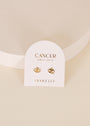 The Zodiac Earrings - Cancer are gold plated studs displayed on a white card reading “CANCER June 21 - July 22” and “JAXKELLY” set on a minimal, neutral-toned backdrop—an elegant choice for any ear piercings collection.