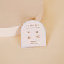 The Birthstone Stud Earring Set - April features three pairs of delicate sterling silver diamond stud earrings, displayed on a JaxKelly Birthstone Collection card labeled April against a soft beige background.