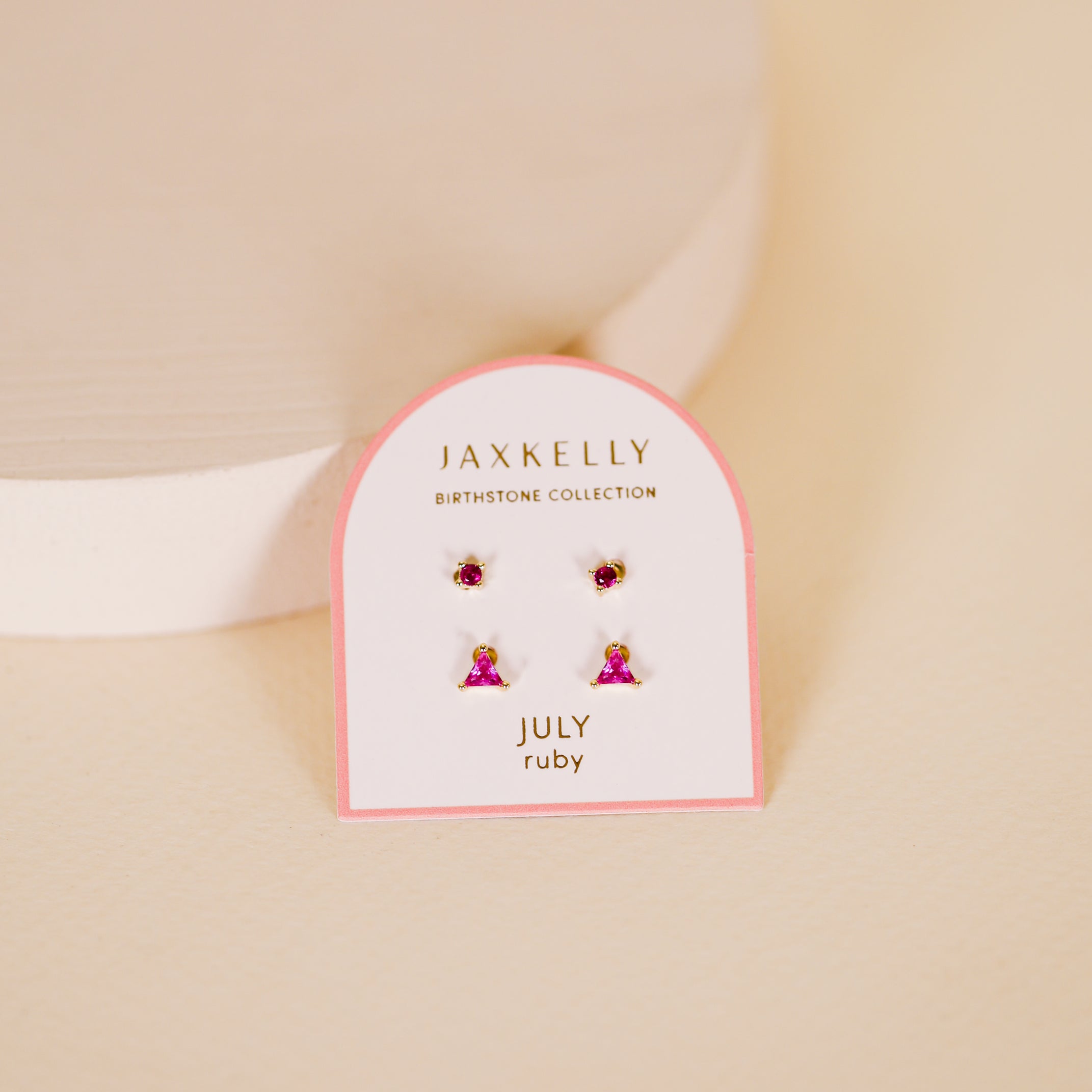 The Birthstone Stud Earring Set - July includes two pairs of ruby-inspired earrings, beautifully displayed on a white and pink card—ideal for celebrating July birthdays.