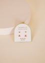 A pair of small birthstone stud earrings with light green stones, labeled "Birthstone Stud Earring Set - August," is displayed on a white card against a soft beige background.