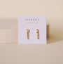 JaxKelly Mini Baguette Drop - White CZ tarnish-free gold earrings with small gemstones, displayed on a white card with "Wear Good Vibes" against a soft beige background.
