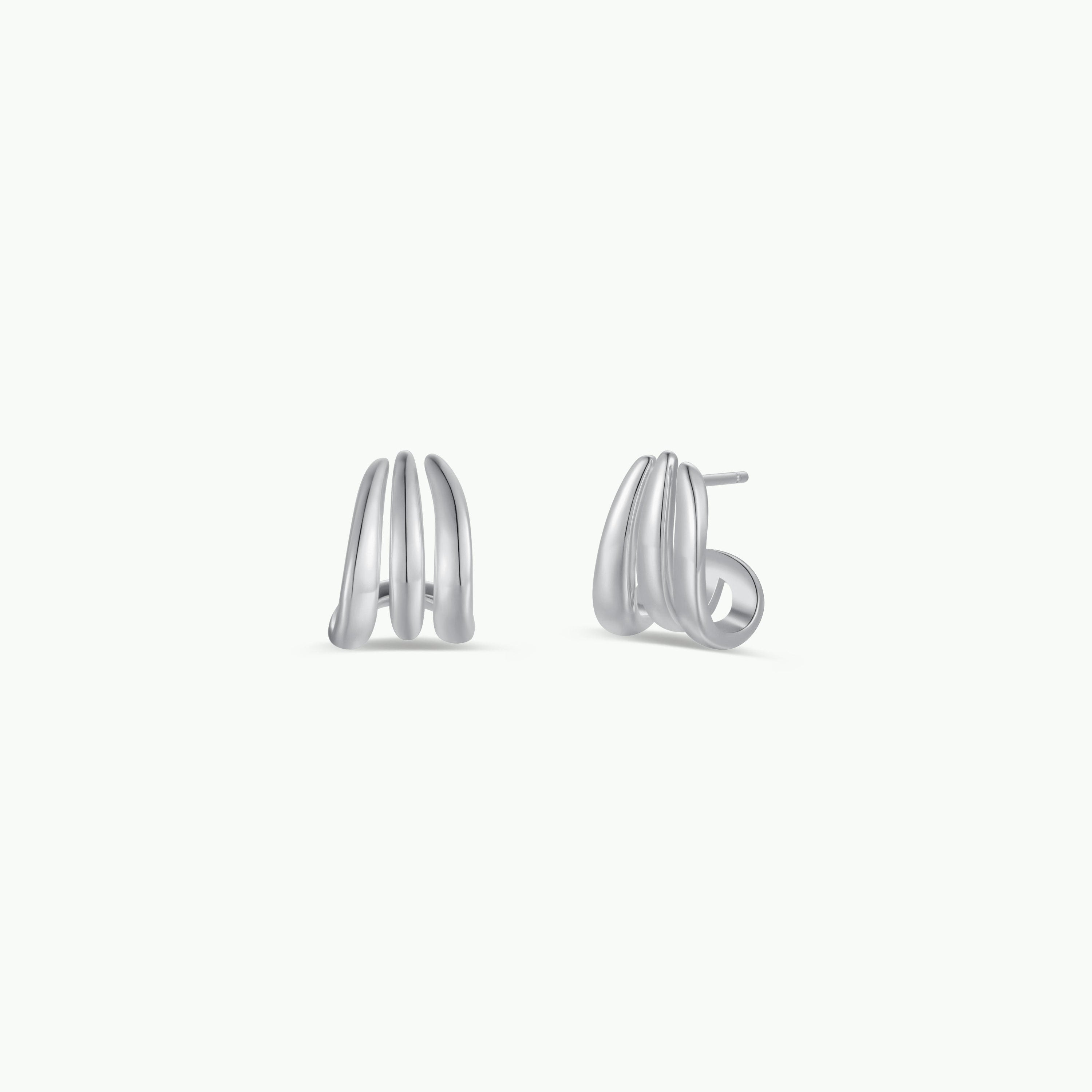 The Silver Three Hoop Huggie is a pair of minimalist sterling silver earrings with a modern, triple-curve design, shown against a plain white background.