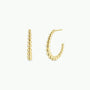 The JaxKelly Large Ball Hoop features tarnish-free gold hoops with graduated spherical beads in a curved design, displayed against a plain white background.