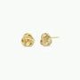 The JaxKelly Petite Gold Knot Earrings feature an intricate knot design with 18K gold plating. Displayed on a white background, one earring shows the front detail while the other highlights the post—ideal for everyday wear.