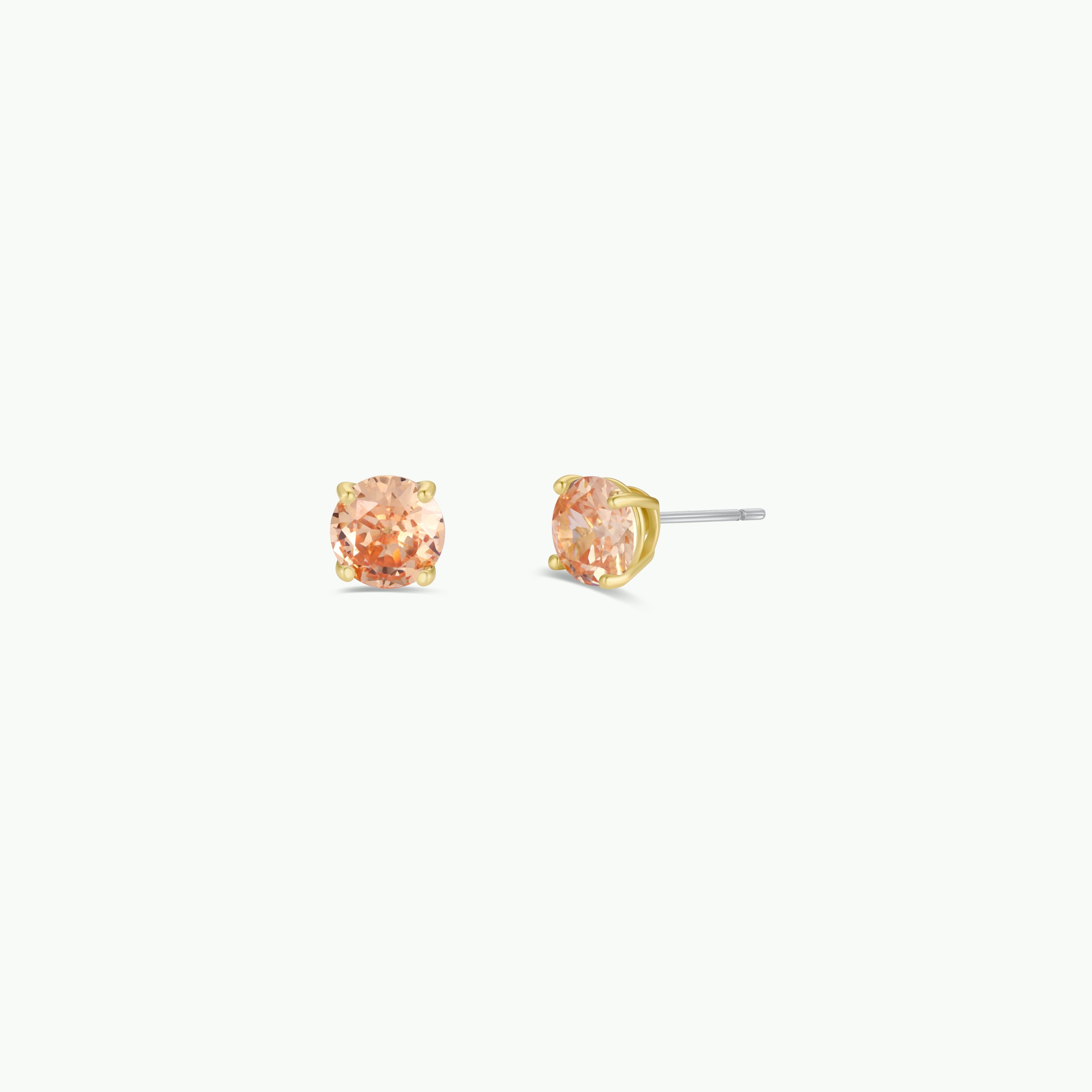 A pair of Round CZ - Champagne - Gold Earrings, featuring minimalist gold-plated studs each set with a round, champagne-colored gemstone, displayed against a plain white background.