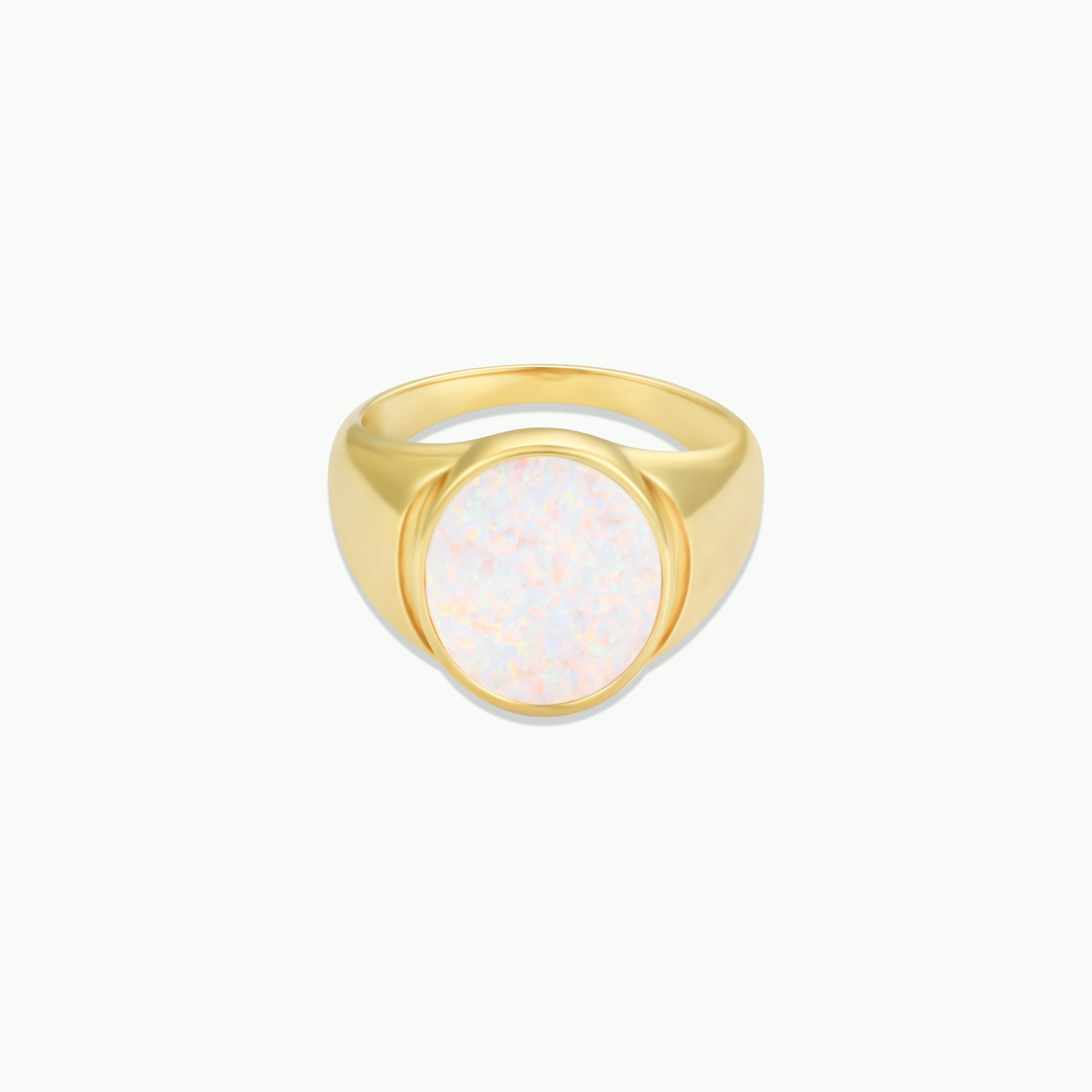 The White Opal Signet Ring features a wide 18k gold plated band and a large, round iridescent stone at the center, beautifully displayed on a plain white background.