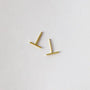 The JaxKelly Minimalist Bar earrings, shown at slight angles on a white background, feature a sleek gold design. Hypoallergenic and modern, they're ideal for daily wear.