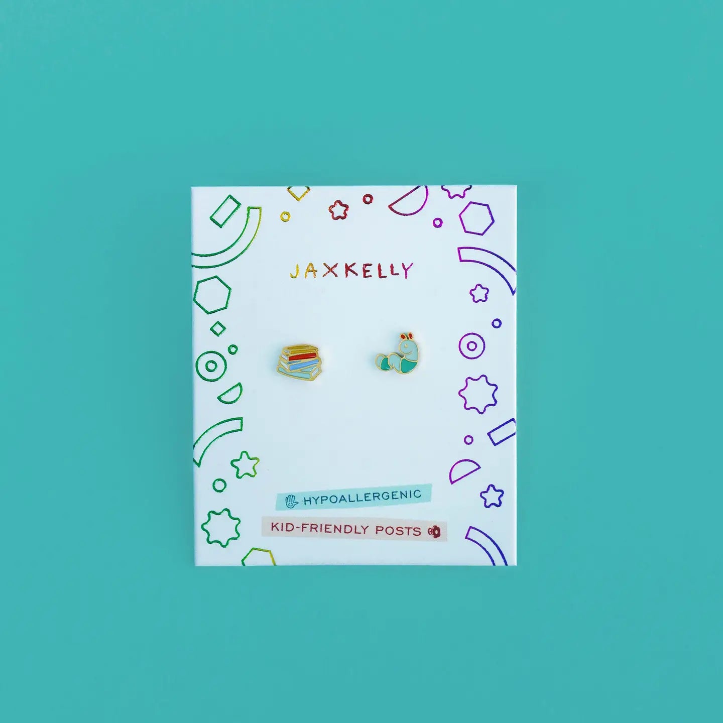 Bookworm Enamel Flat Back Kids Earrings—colorful, hypoallergenic studs for sensitive ears, shaped like a book stack and a globe. Displayed on a white JaxKelly card with playful doodles; features kid-friendly posts.