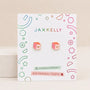 A pair of Pink Dice Enamel Flat Back Kids Earrings by JaxKelly, featuring cube-shaped pink and orange dice with heart details, displayed on a branded card reading “Hypoallergenic and Kid-Friendly Posts” with colorful geometric accents—perfect for sensitive ears.