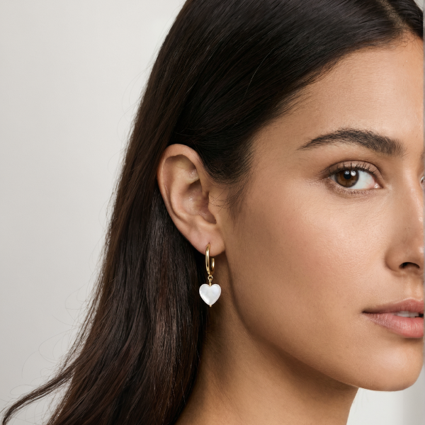 Model wearing gold heart drop earrings