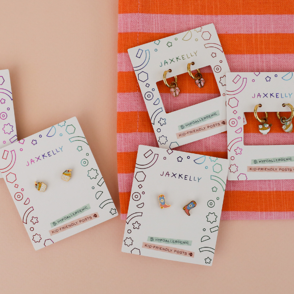 Kids stud earrings on JaxKelly display cards on striped background