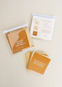 Strength Shower Affirmations™: Square, waterproof affirmation cards in warm brown and beige tones—some stacked, some spread out. The visible card reads, "Every time I fall, I rise again with courage and determination." Reusable quote cards.