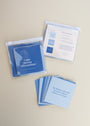 Calm Shower Affirmations™—a set of blue waterproof quote cards—is shown on a light surface. Some are spread out, others in a clear plastic case. One reusable card reads: My mind is calm and focused. I choose clarity over chaos.