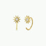 JaxKelly Sun Huggie earrings feature gold-plated sunburst designs with a central sparkling gemstone, shown against a simple light background.