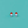 Popsicle Enamel Flat Back Kids Earrings, gold plated and perfect for sensitive ears, feature red tops, white bottoms, and a zigzag blue stripe. Displayed against a solid turquoise background.