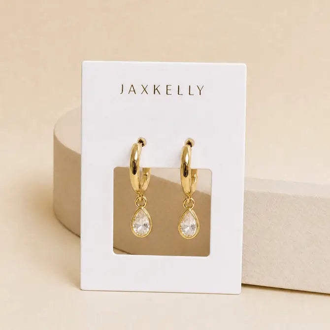 JaxKelly Teardrop Charm Hoop - White CZ earrings on a white display card.