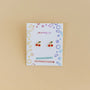 Cherry Enamel Flat Back Kids Earrings displayed on a decorative JaxKelly card labeled "Hypoallergenic and Kid-Friendly Posts," perfect for sensitive ears, shown against a plain beige background.