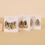 Three pairs of Silver Bold Drop Earrings by JaxKelly are shown on white cards against a beige background. Each features chunky, smooth, or twisted styles with sterling silver posts for quality and comfort.