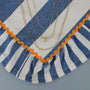 The JaxKelly Tiny Star Necklace, plated in 18k gold, is shown on blue and white striped fabric with orange trim. The delicate design features a sparkling Cubic Zirconia pendant and adjustable length for a layered look.